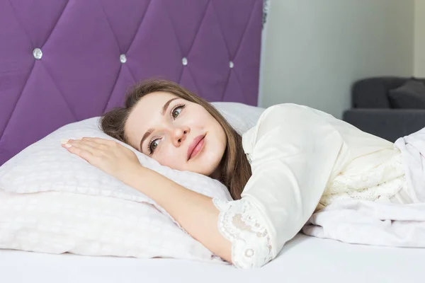 Mooi jong meisje wakker in de ochtend in haar bed. gezondheid en schoonheid — Stockfoto