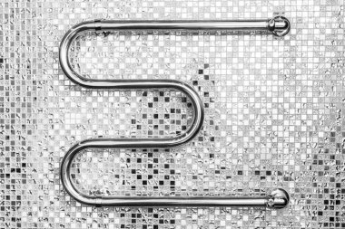 Art deco tarzında banyo iç. Ayna mozaik seramik karoların arka planında krom havlu ısıtıcı