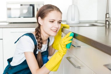 İş sırasında profesyonel ekipmanlarla temizlik hizmeti. Profesyonel mutfak temizliği, kanepe kuru temizleme, pencere ve yer silme. Erkek ve kadın üniformalı, tulumlu ve lastik eldivenli.