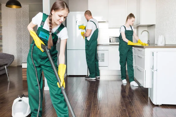 Cleaning service with professional equipment during work. professional kitchenette cleaning, sofa dry cleaning, window and floor washing. man and women in uniform, overalls and rubber gloves — Stock Photo, Image