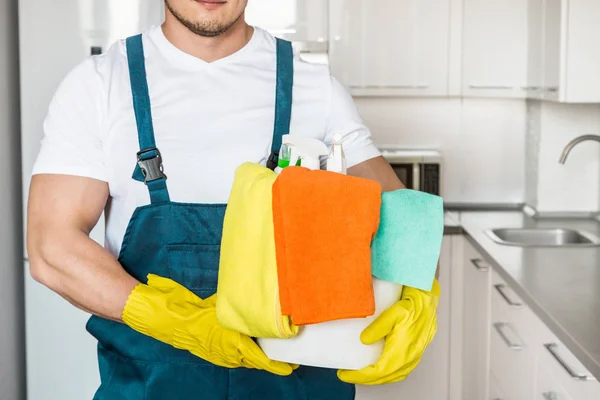 Cleaning service with professional equipment during work. professional kitchenette cleaning, sofa dry cleaning, window and floor washing. man and women in uniform, overalls and rubber gloves