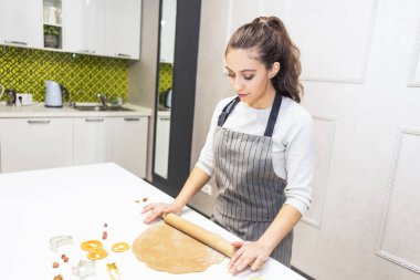 Genç ve güzel bir kadın mutfakta hamur hazırlar, zencefilli ekmek ve kurabiye pişirir. Mutlu Noeller ve mutlu yıllar..