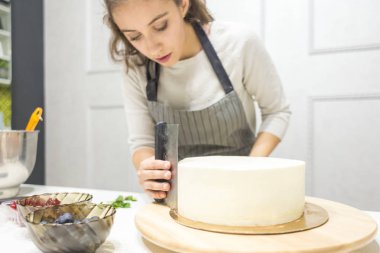 Şekerleme spatulası ile bisküvi pastası üzerine beyaz krema. Ev yapımı hamur işi, kek pişirme....