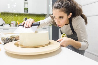 Şekerleme spatulası ile bisküvi pastası üzerine beyaz krema. Ev yapımı hamur işi, kek pişirme....