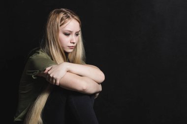 Üzgün genç kadın siyah bir arka planda ağlamaya gidiyor