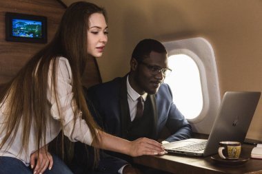 Genç başarılı Afrikalı-Amerikan işadamı gözlük ve çekici bir kadın iş arkadaşı Sarışın özel bir Jet. Hizmet ve uçuş birinci sınıf