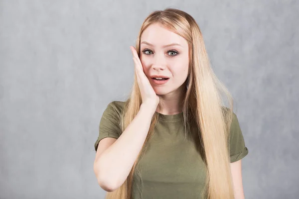 Mujer joven asombrada mira con horror y pánico, siendo sorprendido al escuchar malas noticias . —  Fotos de Stock