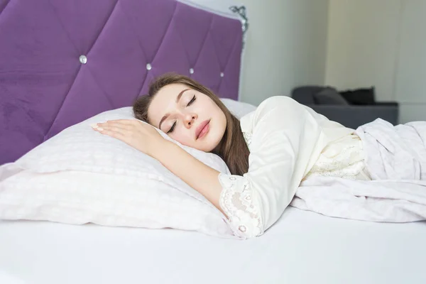 Mooie jonge meisje slapen in haar bed in de ochtend. gezondheid en schoonheid — Stockfoto