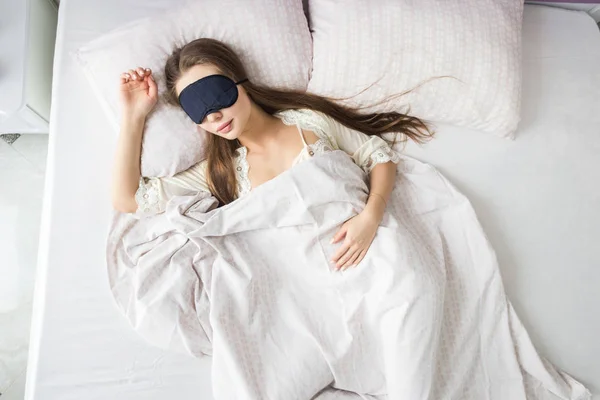 Belle jeune fille qui dort le matin dans son lit avec un masque facial. Vue d'en haut — Photo