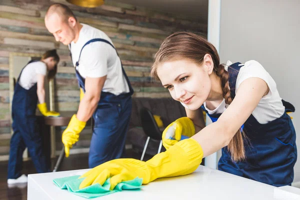 Serviço de limpeza com equipamento profissional durante o trabalho. limpeza kitchenette profissional, sofá limpeza a seco, janela e lavagem de piso. homem e mulher de uniforme, macacão e luvas de borracha — Fotografia de Stock