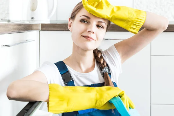 Cleaning service with professional equipment during work. professional kitchenette cleaning, sofa dry cleaning, window and floor washing. man and women in uniform, overalls and rubber gloves