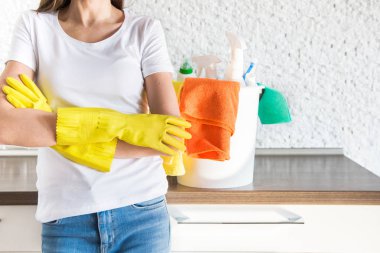 Profesyonel ev temizliği. Genç bir kadın daireyi temizliyor. Yakın plan, paçavra, sünger ve kova, malzeme personeli..