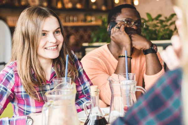 Meet young attractive people in the cafe. Friends chat, have fun, drink cocktails and eat