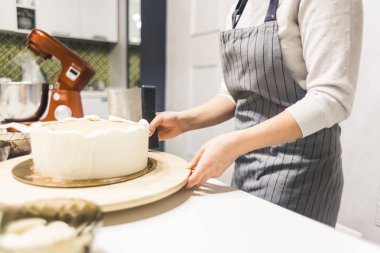 Şekerleme spatulası ile bisküvi pastası üzerine beyaz krema. Ev yapımı hamur işi, kek pişirme....