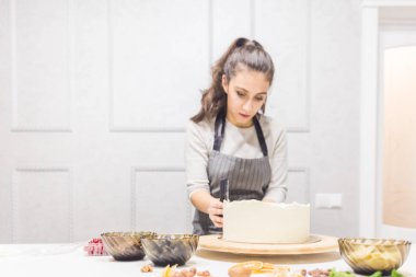 Şekerleme spatulası ile bisküvi pastası üzerine beyaz krema. Ev yapımı hamur işi, kek pişirme....