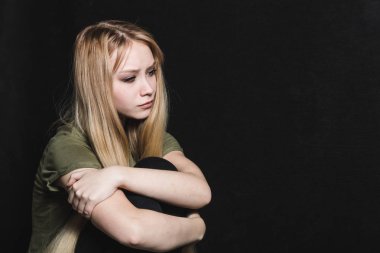 Üzgün genç kadın siyah bir arka planda ağlamaya gidiyor