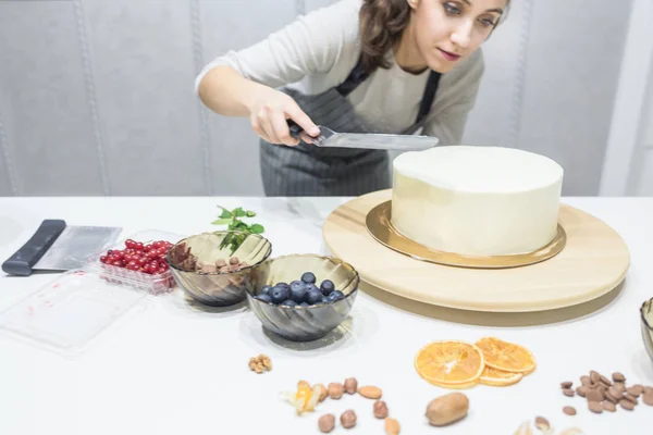 Cukrászda simítja fehér krém egy keksz torta főzés spatula. A házi sütemény, a sütemények koncepciója. — Stock Fotó