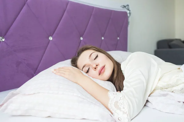 Mooie jonge meisje slapen in haar bed in de ochtend. gezondheid en schoonheid — Stockfoto