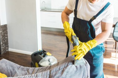 İş sırasında profesyonel ekipmanlarla temizlik hizmeti. Profesyonel mutfak temizliği, kanepe kuru temizleme, pencere ve yer silme. Erkek ve kadın üniformalı, tulumlu ve lastik eldivenli.