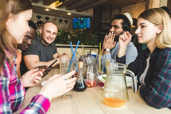 Meet young attractive people in the cafe. Friends chat, have fun, drink cocktails and eat