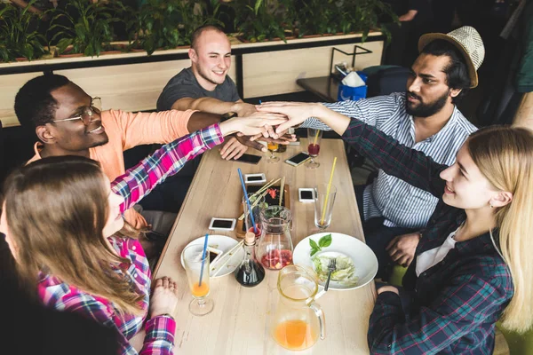 Meet young attractive people in the cafe. Friends chat, have fun, drink cocktails and eat