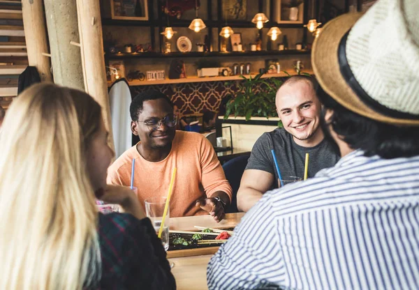 Meet young attractive people in the cafe. Friends chat, have fun, drink cocktails and eat