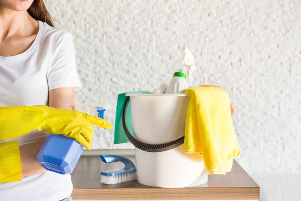 Professzionális takarítás. Egy fiatal nő takarítja a lakást. Közelkép, rongyok, szivacsok és vödör, kellékek személyzet. — Stock Fotó