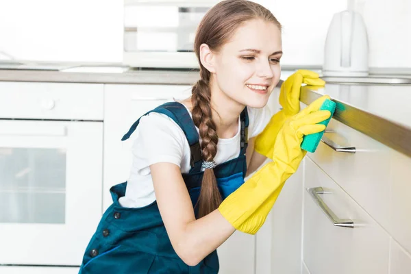 Sprzątanie z profesjonalnym sprzętem podczas pracy. profesjonalne sprzątanie aneksem kuchennym, suszarka do kanapy, mycie okien i podłóg. mężczyźni i kobiety w mundurach, kombinezonach i gumowych rękawiczkach — Zdjęcie stockowe
