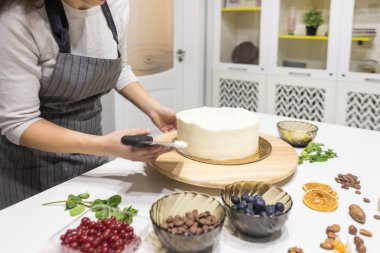 Şekerleme spatulası ile bisküvi pastası üzerine beyaz krema. Ev yapımı hamur işi, kek pişirme....