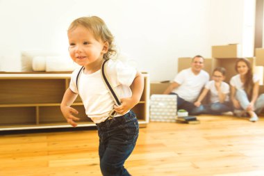 Mutlu, genç bir aile, anne-baba, kız ve oğul, kutuları açıp yeni bir eve taşınıyorlar. Komik çocuklar kutularla gelir.