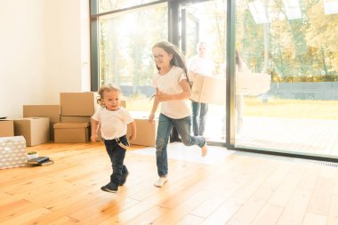 Mutlu, genç bir aile, anne-baba, kız ve oğul, kutuları açıp yeni bir eve taşınıyorlar. Komik çocuklar kutularla gelir.