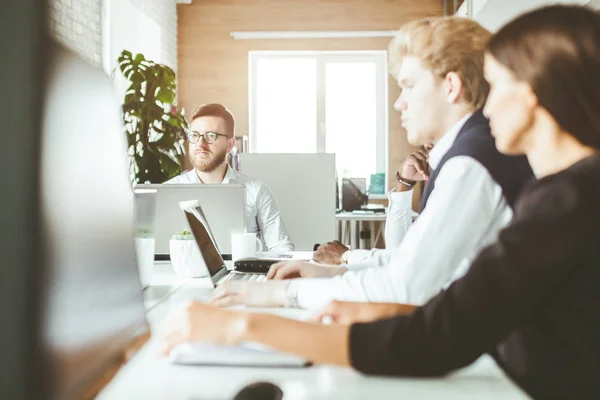 Un equipo de jóvenes empresarios que trabajan y se comunican en una oficina. Corporativossteam y gerente en una reunión. — Foto de Stock