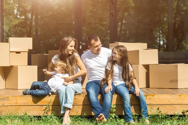Ung familj med son och dotter flyttar till ett nytt lanthus. flyttdagen. — Stockfoto