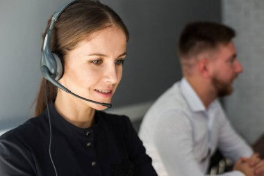 Kadın müşteri hizmetleri çalışanı portresi, çağrı merkezi gülümseyen operatör ve ofis telefonu.