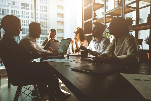 Un equipo de jóvenes empresarios que trabajan y se comunican en una oficina. Corporativossteam y gerente en una reunión. — Foto de Stock