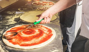 Oteldeki mutfak restoranında yemek pişiren profesyonel bir aşçı. Yemek hazırlıyor. Önlüklü bir aşçı sebze ve pizzadan salata yapar..