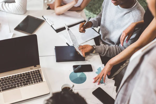 Un equipo de jóvenes trabajadores de oficina, empresarios con portátil trabajando en la mesa, comunicándose juntos en una oficina. Corporativosvapor y gerente en una reunión. coworking. — Foto de Stock