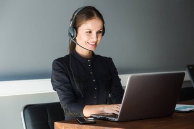 Kadın müşteri hizmetleri çalışanı portresi, çağrı merkezi gülümseyen operatör ve ofis telefonu.