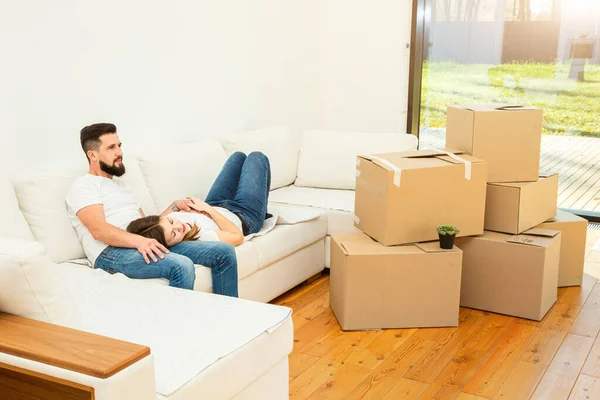 Unga par flyttar till ett nytt hem. familjen bär lådor med saker efter att ha köpt ett hem. — Stockfoto