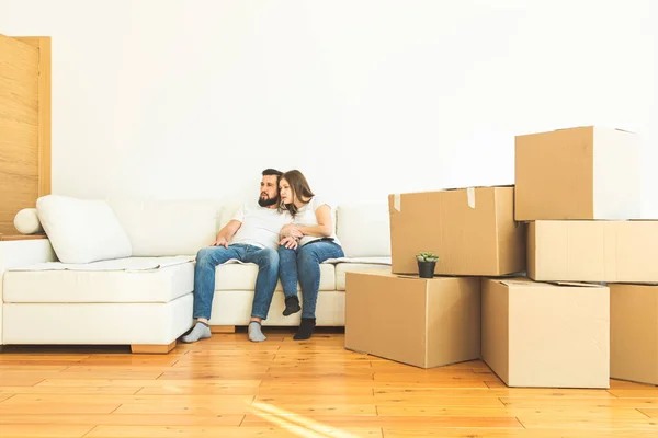 Pareja joven se muda a un nuevo hogar. la familia lleva cajas de cosas después de comprar una casa . — Foto de Stock