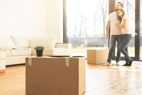 Pareja joven se muda a un nuevo hogar. la familia lleva cajas de cosas después de comprar una casa . — Foto de Stock