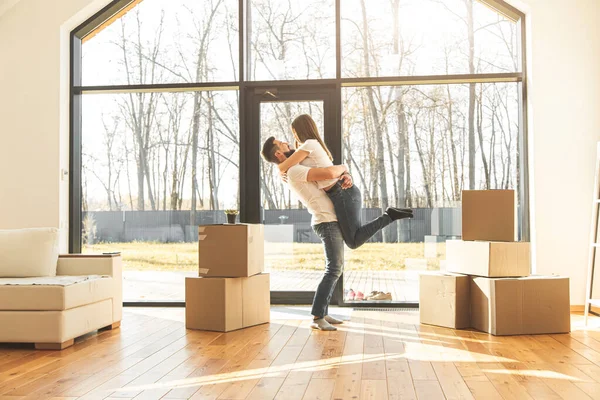 Pareja joven se muda a un nuevo hogar. la familia lleva cajas de cosas después de comprar una casa . — Foto de Stock