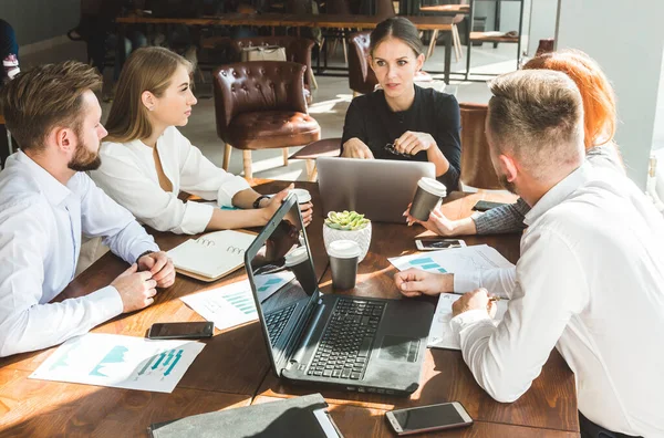 Un equipo de jóvenes empresarios que trabajan y se comunican en una oficina. Corporativossteam y gerente en una reunión. — Foto de Stock