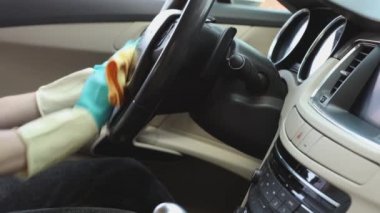 Profesyonel araba temizliği. Adam direksiyonu kuru temizleme beziyle siliyor.