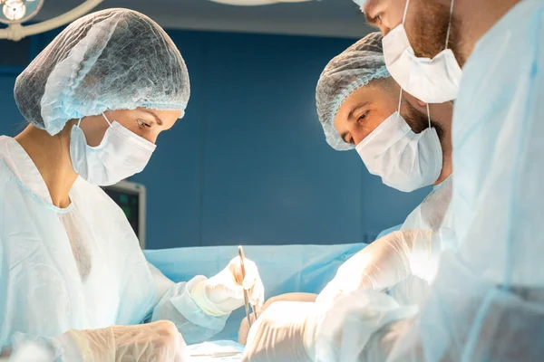 Uluslararası bir doktor ekibi, anestezi altındaki bir hastaya karmaşık bir ameliyat uygular. Modern ameliyathane ve deneyimli cerrahlar hayat kurtarıyor. — Stok fotoğraf