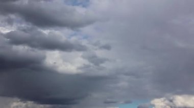 Mavi gökyüzüne karşı yüzen yağmur bulutlarının dramatik bir zaman kayması. Yaklaşan bir fırtınanın atmosferik videosu