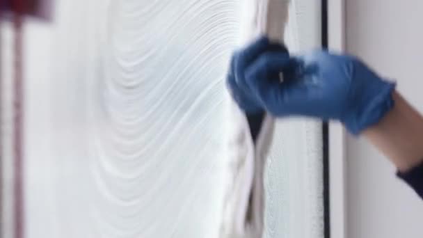 Un nettoyeur de vitres professionnel savonne et serre une vitre propre, travailleur de nettoyage masculin. — Video