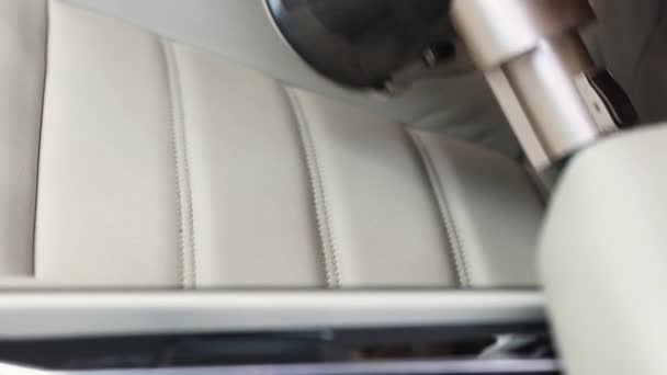 Επαγγελματική υπηρεσία καθαρισμού εσωτερικών χώρων αυτοκινήτων. Κοντινό πλάνο λεπτομερούς σκούπισης ελαφρών δερμάτινων καθισμάτων σε πολυτελές σεντάν — Αρχείο Βίντεο