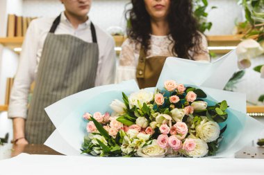 Çekici, deneyimli bir kadın çiçekçi genç bir adama çiçekçide nasıl çalışacağını öğretiyor..