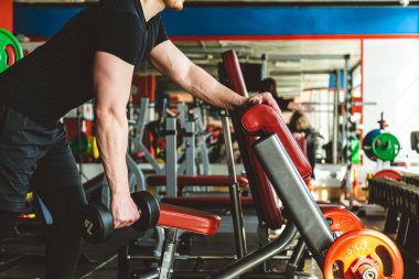 Spor salonunda dambıllarla antrenman. Dayanıklılık egzersizleri.